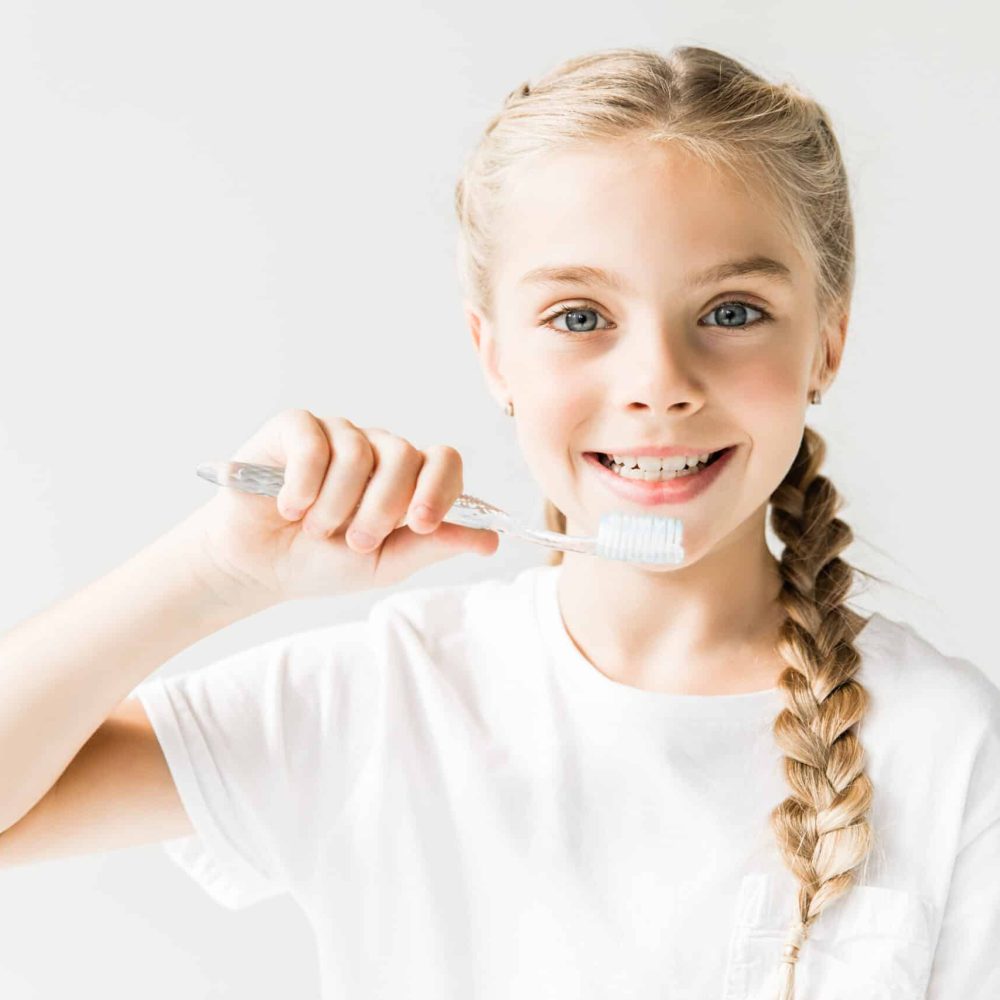 Kids Dental Care in Rigby, Idaho PREVENTATIVE HYGIENE rigby pediatric dental dentist in rigby ID Adorable,Happy,Child,Brushing,Teeth,And,Smiling,At,Camera,Isolated Kids Dental Care in Rigby, Idaho PREVENTATIVE HYGIENE rigby pediatric dental dentist in rigby ID